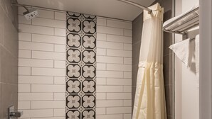Une salle de bain avec une baignoire, des toilettes et un rideau de douche.