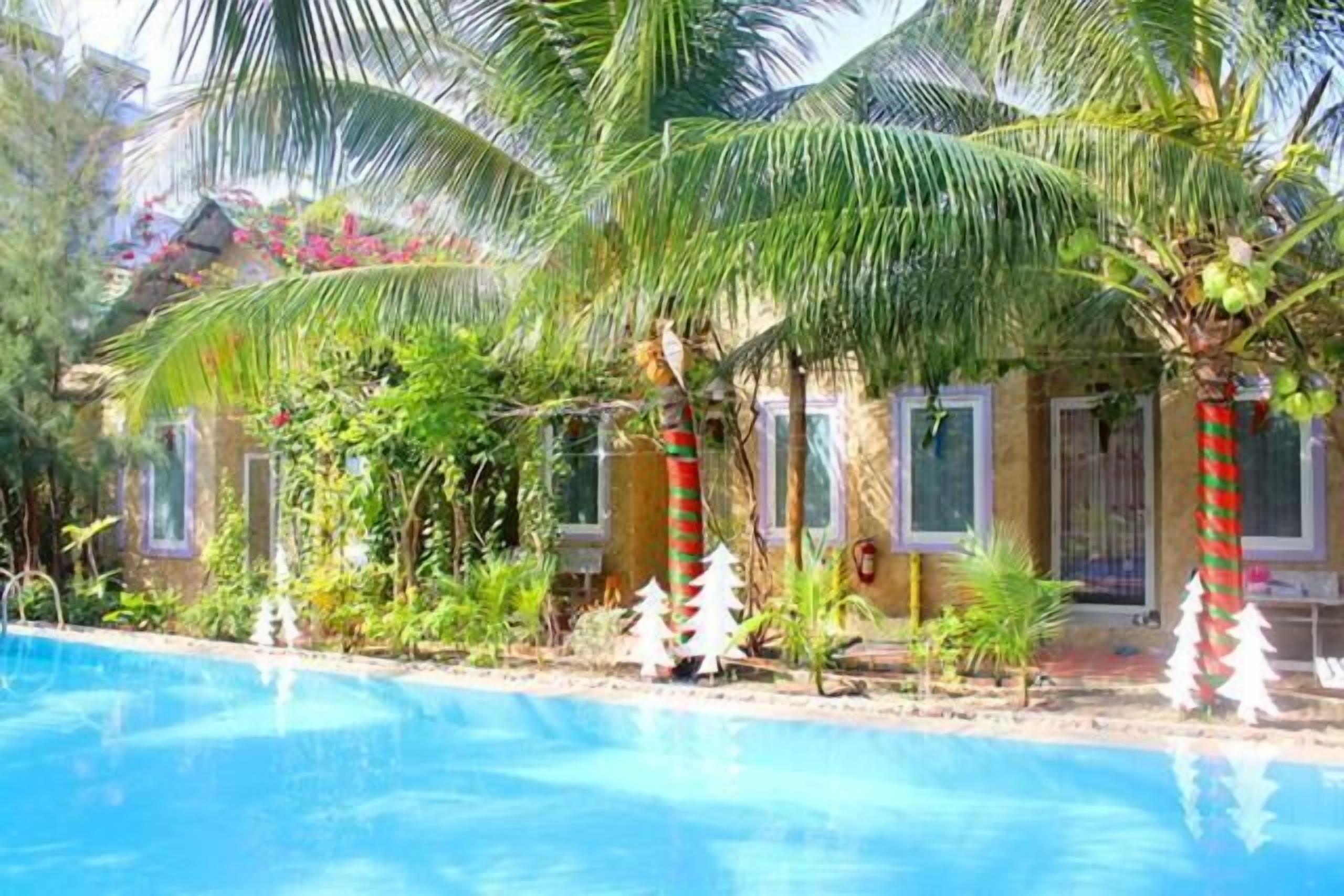 A poolside area with palm trees, a building with windows, and a small pool.