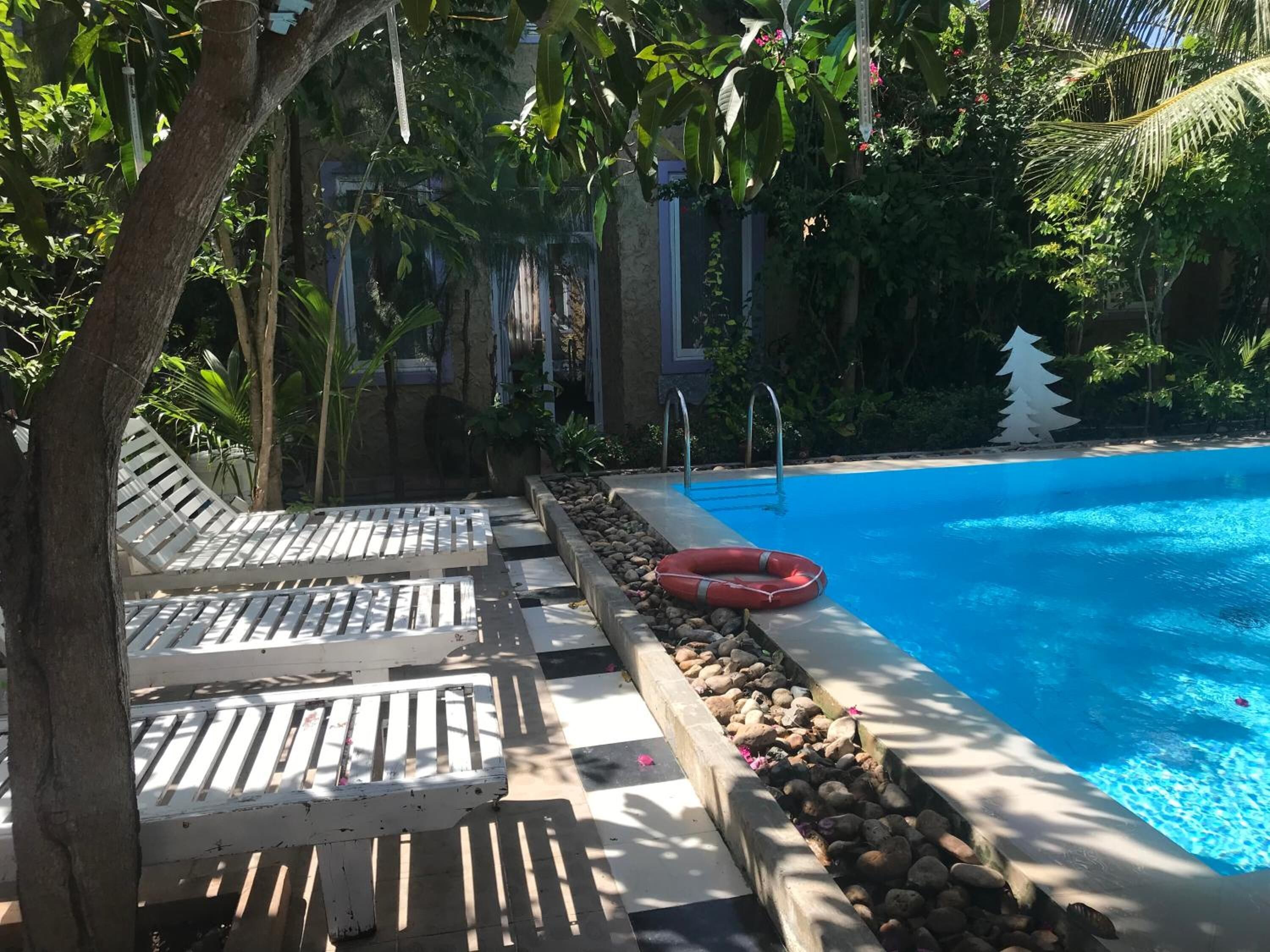 A pool area with lounge chairs and a lifebuoy.