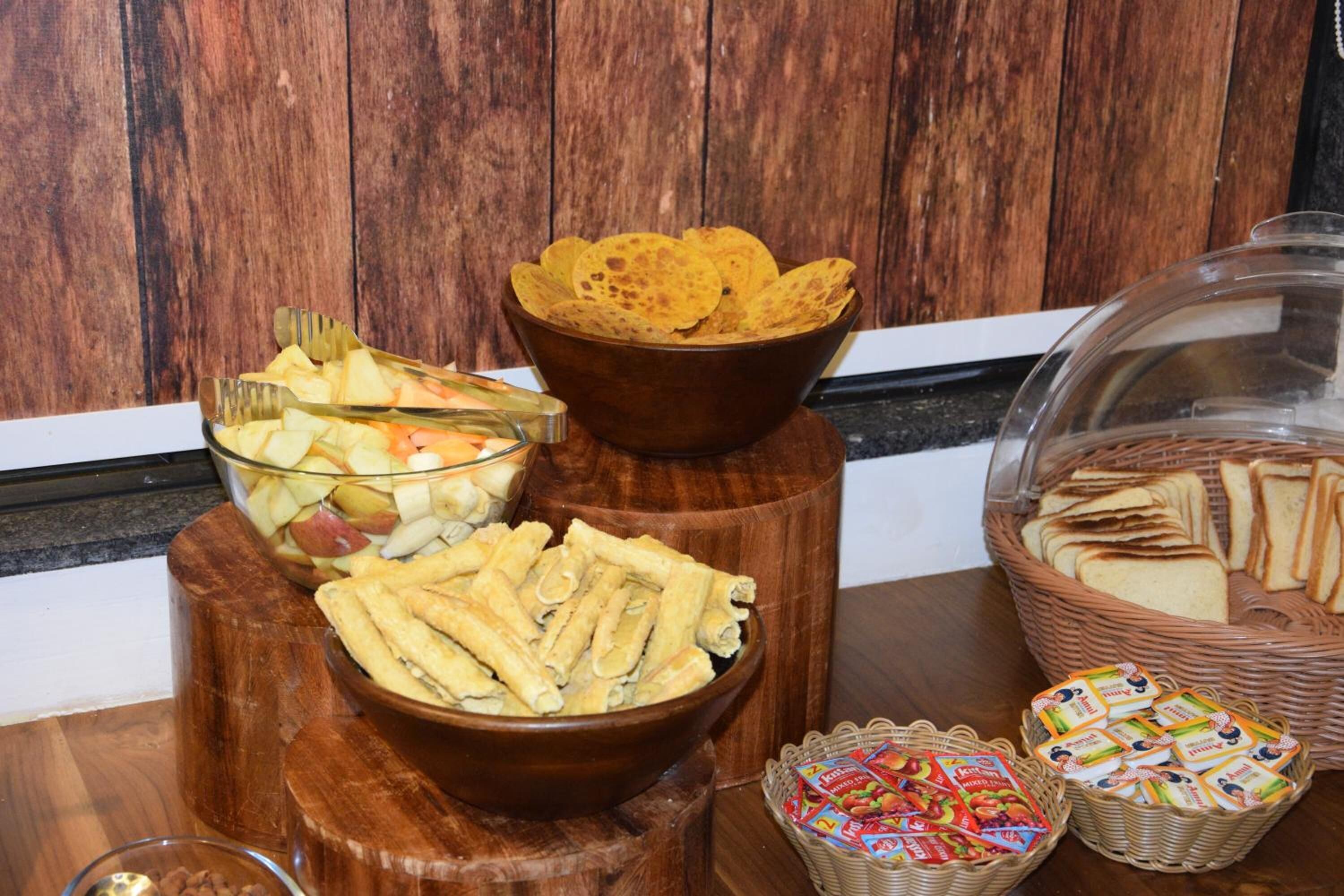 Un bufet amb diversos plats, com ara patates fregides, fruita, entrepans i galetes.