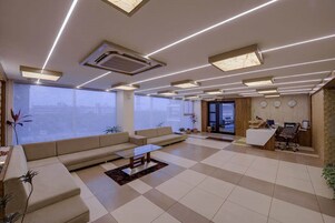 Un salón amplio con un sofá grande, una mesa de centro y una recepción.