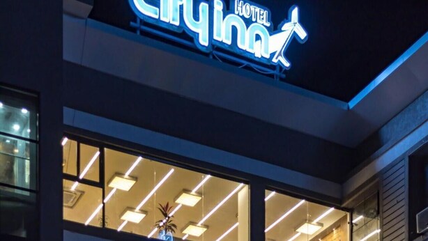 A hotel sign with the name "City Inn" and a running figure. - Hotel CityInn (Gandhinagar)