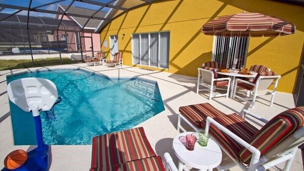 A pool area with a hot tub, lounge chairs, and a dining table with chairs. - Sm218320 - Vizcay - 3 Bed 2 Baths Villa (Davenport)