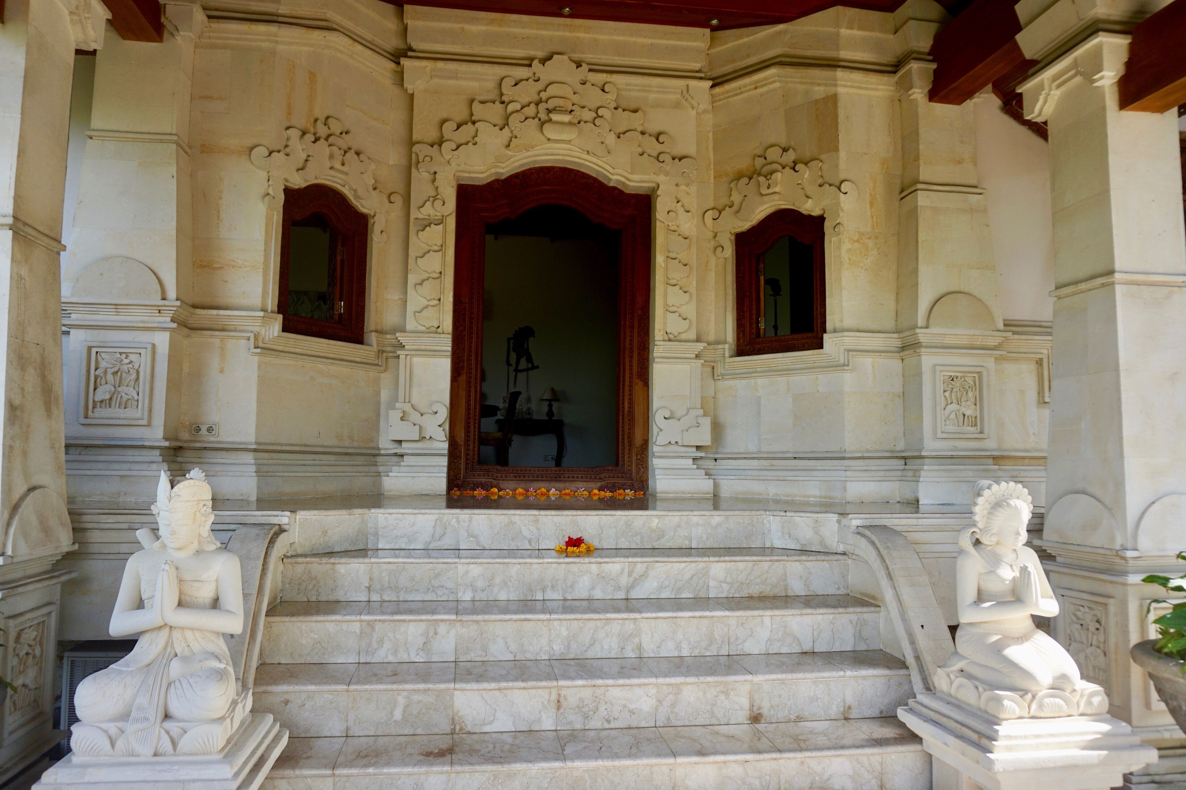 A grand entrance with ornate carvings and a statue of a seated figure.