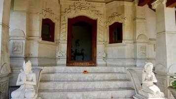 A grand entrance with ornate carvings and a statue of a seated figure.