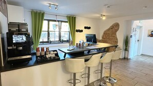 En moderne bar med kaffemaskine, barstole og en disk med menu.