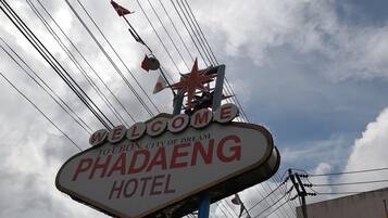 A sign for the Phadaeng Hotel with a star and welcome message.