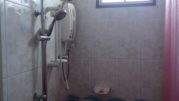 Un baño con ducha, ventana e inodoro.