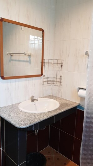 A bathroom with a white sink, a mirror, and a towel rack.