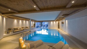 A spa area with a pool, seating, and candles. - Residence Cesa Sassela (Ortisei)