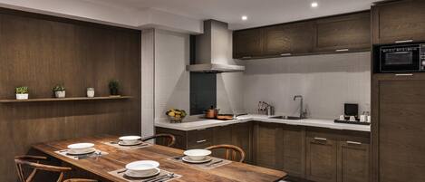 A modern kitchen with a wooden dining table, built-in cabinets, and a microwave.