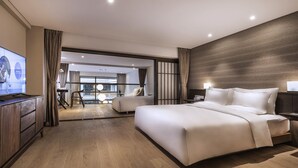 Une chambre d’hôtel moderne avec un grand lit, une télévision et une vue sur la ville.