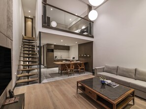 A modern interior with a staircase, a dining area, a sofa, and a coffee table. - Novotel Suites Shanghai Hongqiao Hotel (Shanghai)