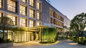 A modern hotel with a prominent entrance, multiple floors, and a well-lit facade. - Novotel Suites Shanghai Hongqiao Hotel (Shanghai)