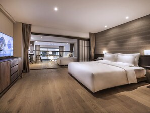 Ein modernes Hotelzimmer mit einem großen Bett, einem Fernseher und Blick auf die Stadt.