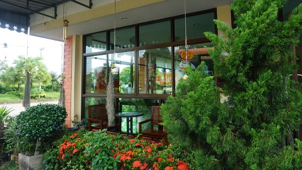 A building with large windows, outdoor seating, and greenery. - Thapap Resort (Trang)