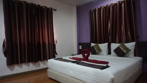 A hotel room with a large bed, dark curtains, and a simple, clean design. - Thapap Resort (Trang)