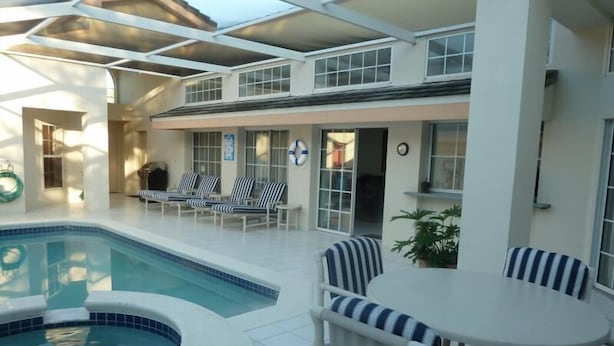 Un área de piscina interior con sillones de descanso y una mesa.