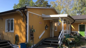 Ein Holzgebäude mit einem Empfangsschild, einer Flagge und einer grün gestrichenen Tür mit der Nummer 11.