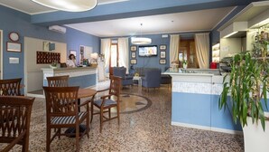 A hotel lobby with a reception desk, seating area, and a television. - Hotel & terme Bagni di Lucca (Bagni di Lucca)
