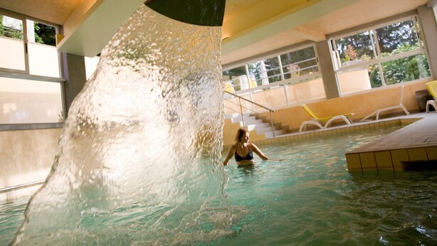 A swimming pool with a water feature, indoor seating, and a view of the outdoors. - Hotel & terme Bagni di Lucca (Bagni di Lucca)