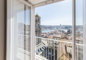 Vista desde una ventana sobre un paisaje urbano con edificios históricos y un río.