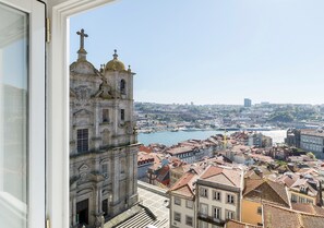 A view from a window overlooking a historic church with a river and cityscape.