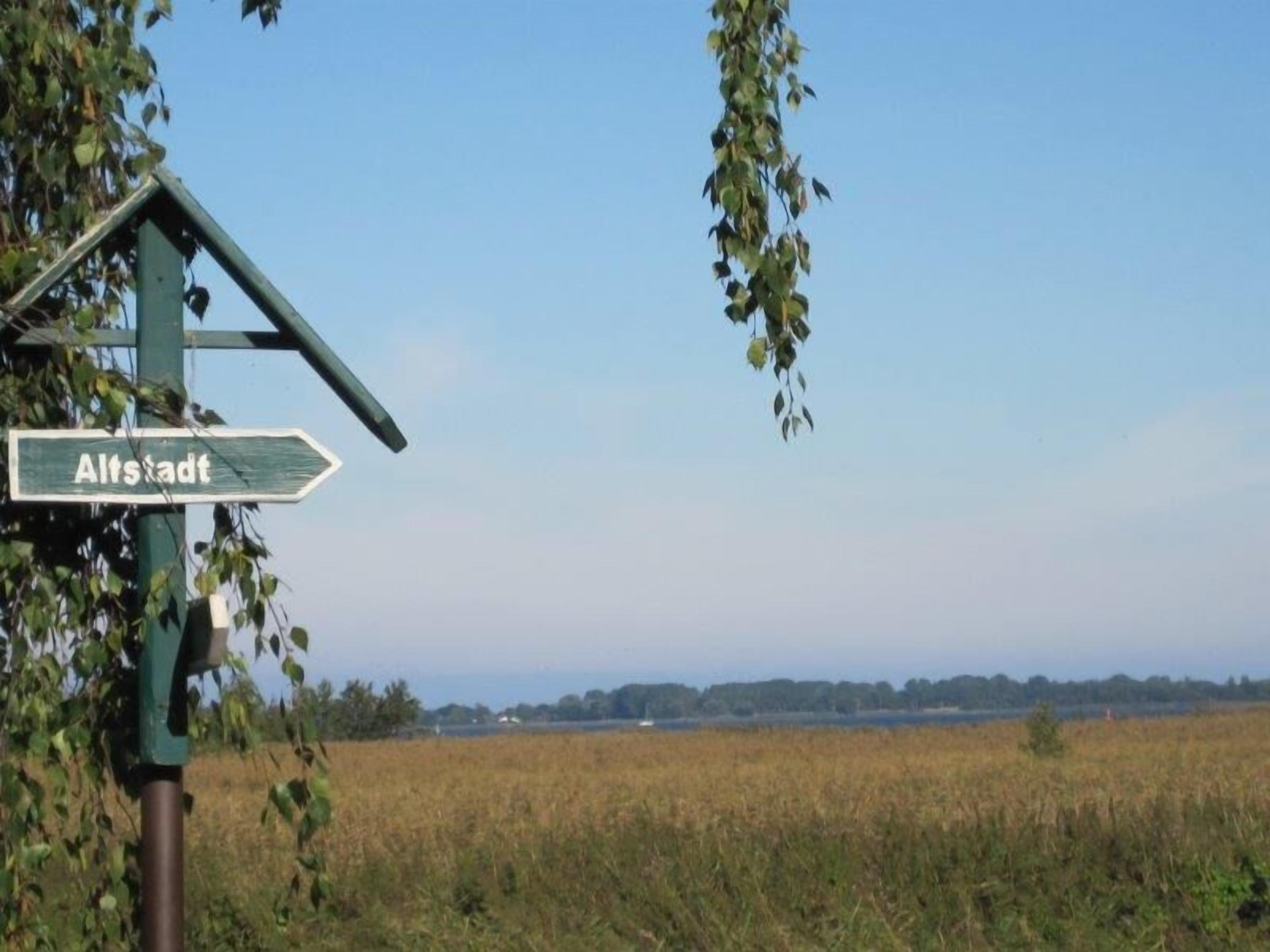 A directional signpost in a rural setting with a field in the background.