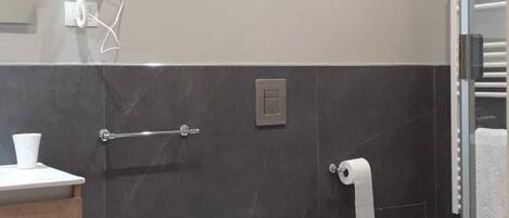 Un baño moderno con bidé, inodoro y lavamanos.