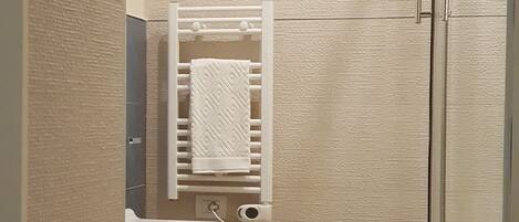 A modern bathroom with a toilet, bidet, and a glass shower enclosure.
