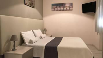 Relax in comfort with a large bed, flat-screen TV, and a stylish artwork on the wall.