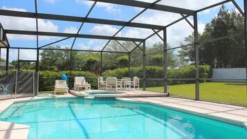 Relax by the pool surrounded by lush greenery and comfortable lounge chairs.
