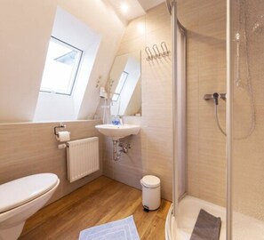 A modern bathroom with a toilet, sink, and shower.
