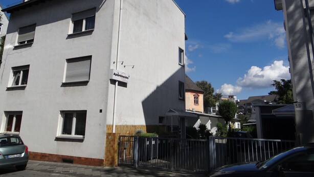 Un edificio residencial de varios pisos con un letrero que indica que es un complejo de apartamentos.