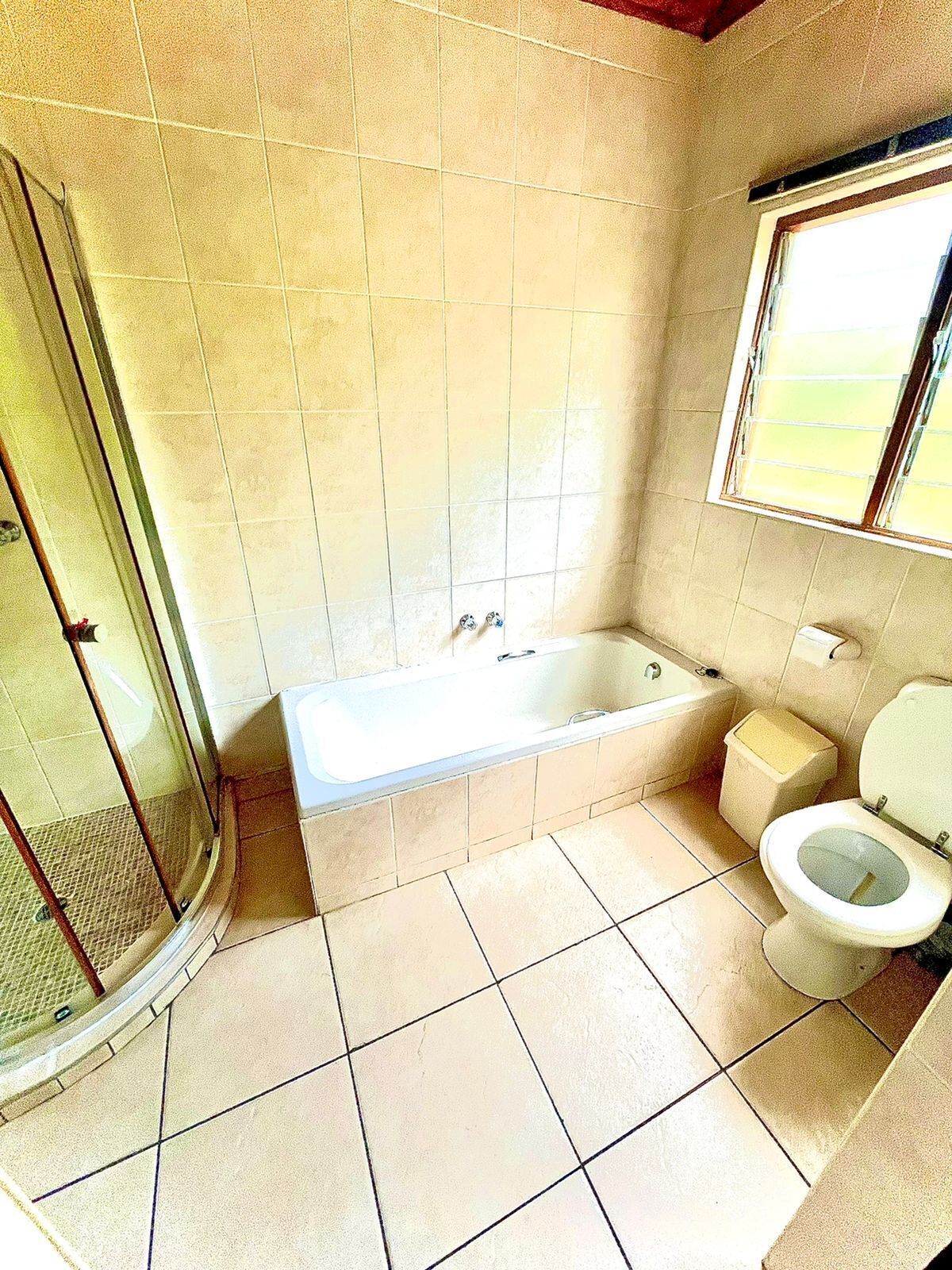 A bathroom with a bathtub, toilet, and a shower area.