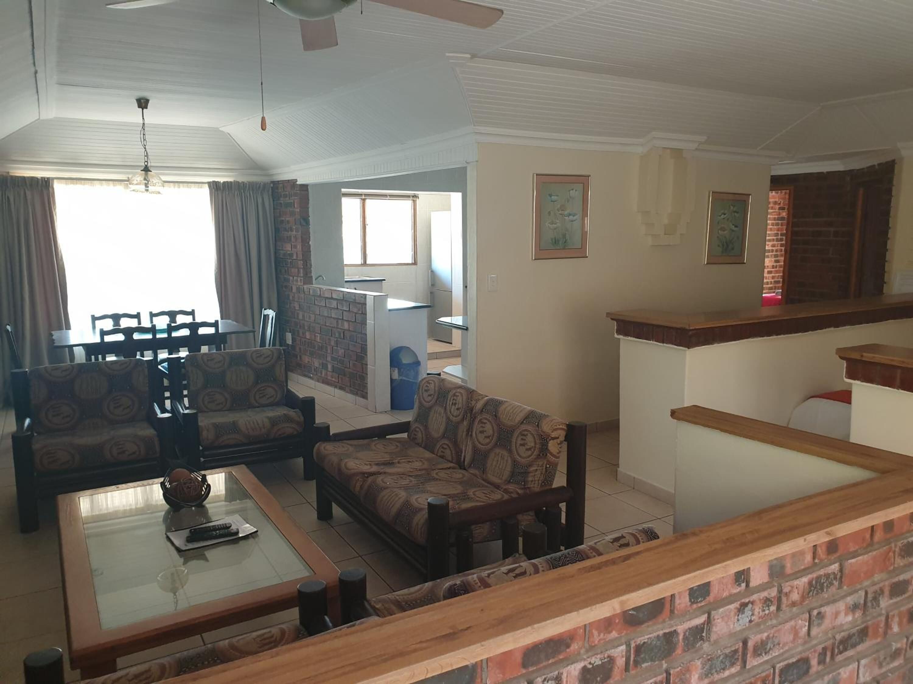 A living room with a sofa set, a coffee table, and a dining area with chairs and a table.