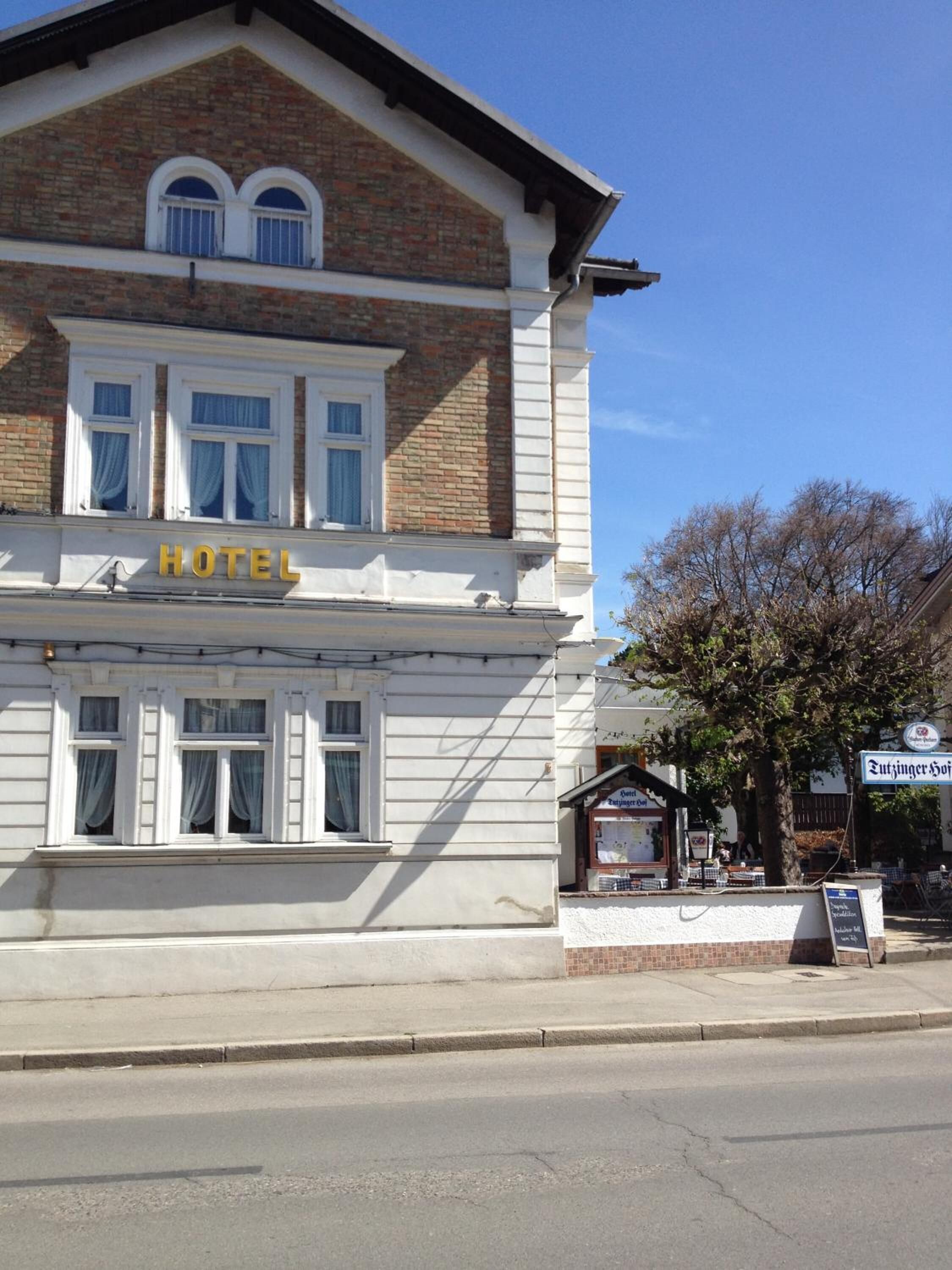 A hotel with a brick facade, white trim, and a sign reading "HOTEL".
