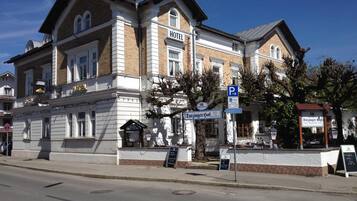 A historic hotel with a classic facade, a prominent entrance, and a visible parking sign.