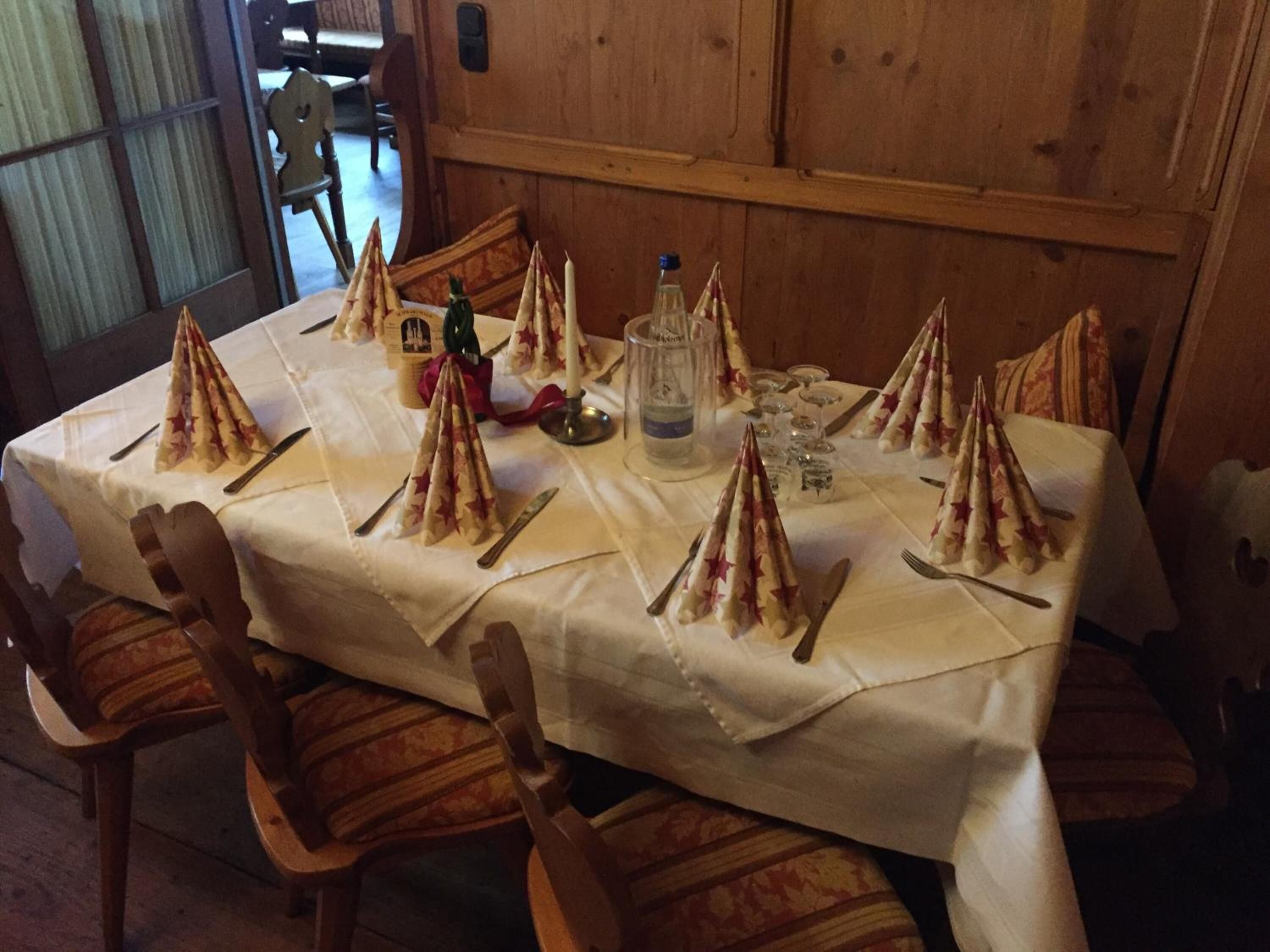 A table set for a meal with star-shaped napkins, a bottle of water, and glasses.