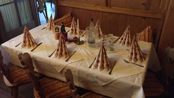 A table set for a meal with star-shaped napkins, a bottle of water, and glasses.