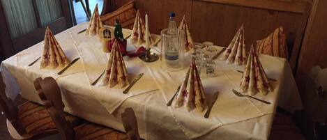 A table set for a meal with star-shaped napkins, a bottle of water, and glasses.