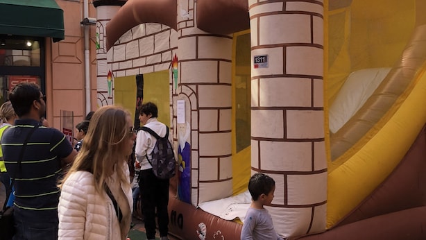 A castle-themed inflatable play area with a slide and climbing wall.