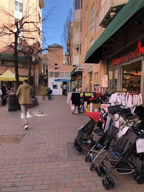 A pedestrian street with shops, including a visible storefront with a sign reading "Babymagasinet".