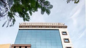 A hotel with a modern glass facade, a sign reading "Goldfinch Express," and a set of stairs leading to the entrance. - Hotel Blue Ocean Residency (Bengaluru)