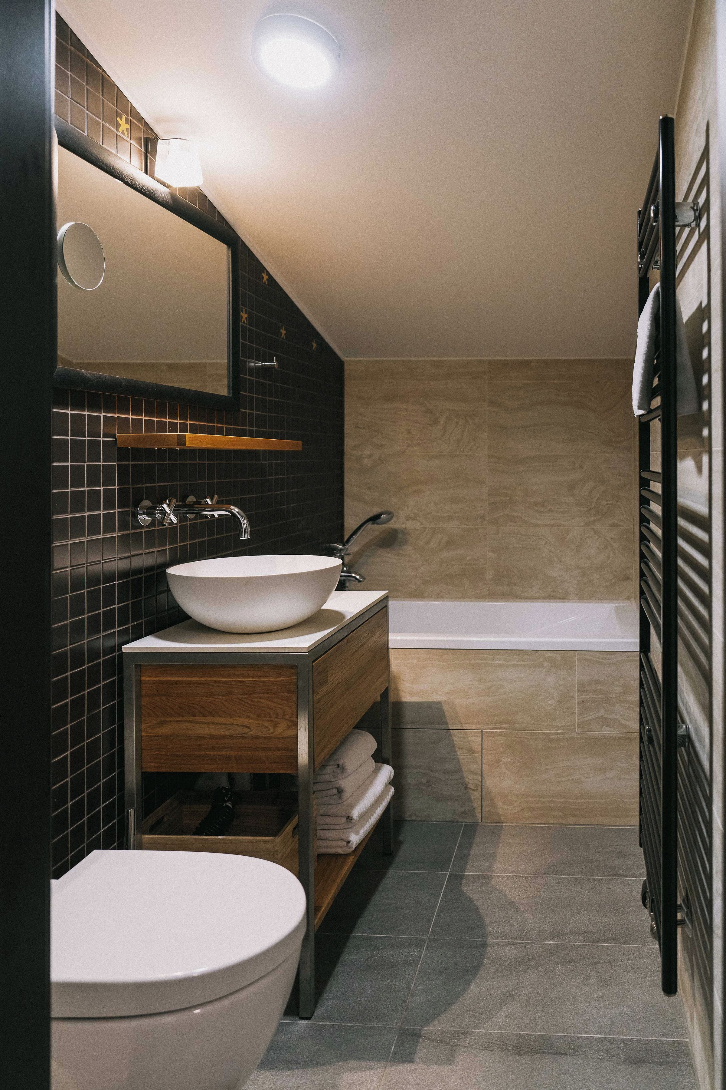 A modern bathroom with a white sink, a toilet, and a bathtub.