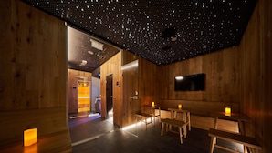 Un interior de madera con techo estrellado, bancos de madera y un televisor de pantalla plana.