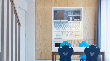 Una cocina moderna con armarios de madera, una encimera blanca y dos sillas azules con forma de corazón.