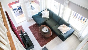 A modern living room with a sectional sofa, a coffee table, and a view of the outdoor area.