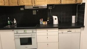 A kitchen with wooden cabinets, a Bosch dishwasher, a Siemens oven, and a black countertop.
