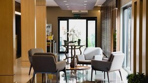 A modern lobby with a glass coffee table, comfortable seating, and a view of the outdoors. - Class Hotel Alfenas (Alfenas)